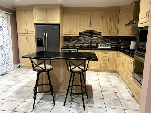 a kitchen with a black counter and a refrigerator at Room for Rent Room 1 in Brampton