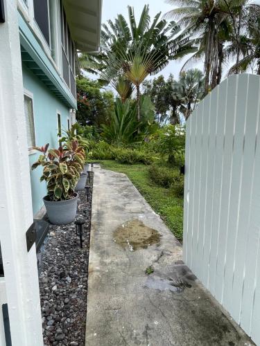 a white fence next to a house with plants at Hale O Malu at Kaloli Point in Keaau