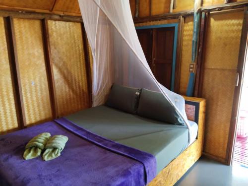 a bed in a room with a mosquito net at Andaman Bay Bungalow in Ko Lanta