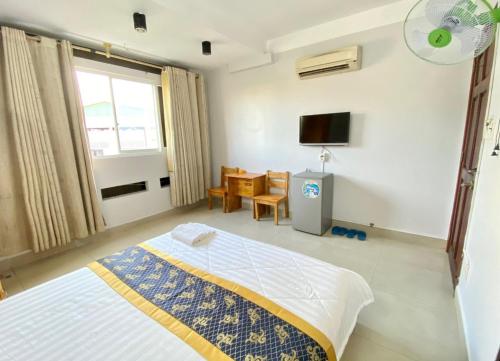 um quarto com uma cama e uma televisão em Khách Sạn Thiên Sơn em Cidade de Ho Chi Minh