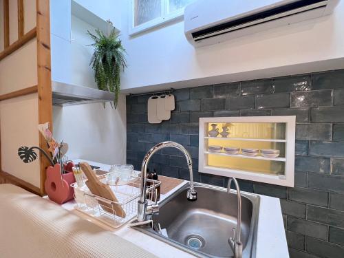 a kitchen with a stainless steel sink and a counter at 台南悠然民宿unabnb in Tainan