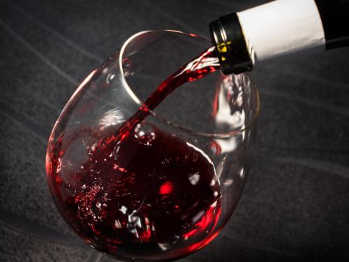 a bottle of red wine being poured into a wine glass at Villa Fontaine Premier Haneda Airport in Tokyo