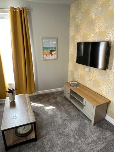 a living room with a flat screen tv on a wall at O’er The Yard Hideaway in Blackpool
