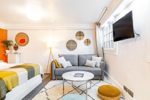 una pequeña sala de estar con sofá y TV en Modern Apartement Grand Paris, TV Salon, Sharing Garden, Villa des Ammonites, en Meudon