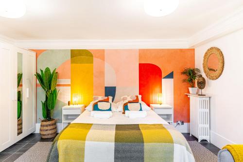 1 dormitorio con 1 cama y una pared colorida en Modern Apartement Grand Paris, TV Salon, Sharing Garden, Villa des Ammonites, en Meudon