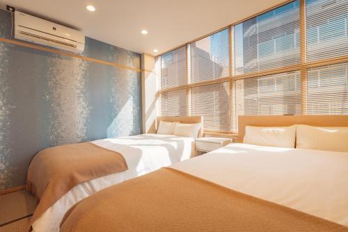 1 dormitorio con 2 camas y ventana en 谷町君・星Hotel・道頓福居 en Osaka