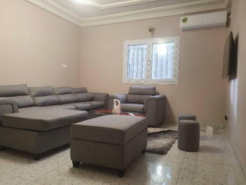 uma sala de estar com um sofá e uma mesa em MediSweet Apartments Meublés em Yaoundé