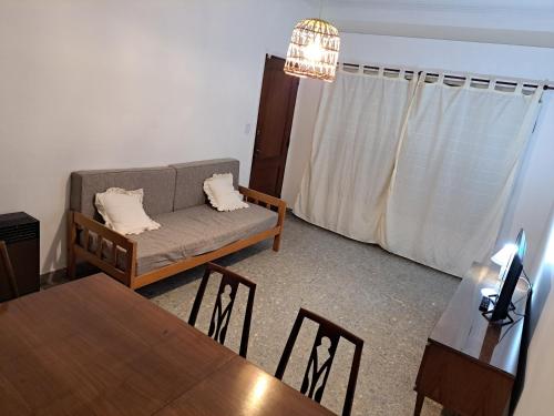 uma sala de estar com um sofá e uma mesa em Hostel Belgrano Home em Monte Grande