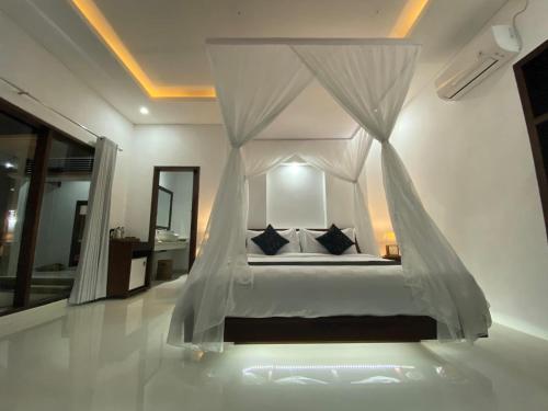 1 dormitorio con 1 cama con dosel en Namika Ubud en Tegalalang