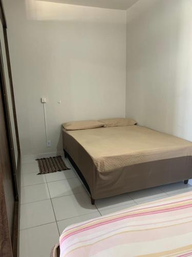um quarto com uma cama num quarto branco em Loft no centro de Araxá em Araxá