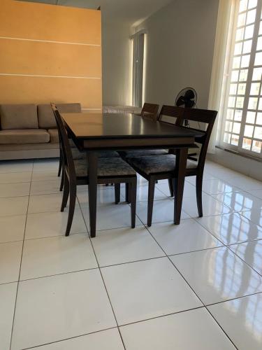 uma mesa de jantar e cadeiras num piso de azulejo em Loft no centro de Araxá em Araxá