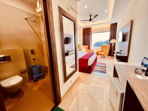 Habitación de hotel con cama y baño en Ganges Blossam, Haridwar-Rishikesh Road - A Four Star Luxury Hotel en Rishīkesh