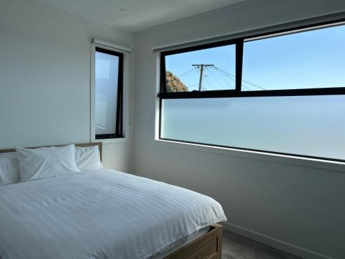 a bedroom with a bed and a large window at New 2-story house with 4 bedrooms and 3 shower rooms in Burwood