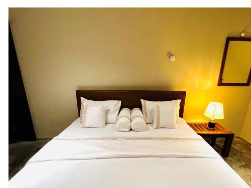 ネゴンボにあるCeylon Kingsmen Garden Hotel - Katunayakeのベッドルーム1室(白い枕2つ付きのベッド1台付)