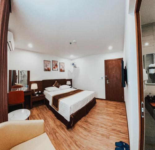1 dormitorio con 1 cama, escritorio y 1 habitación en LuxTel Hotel Tây Hồ, en Hanói