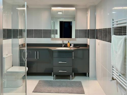 a bathroom with a sink and a toilet and a mirror at NEW Seaview Bachelor Apartment Privacy + Closets in Mudanya