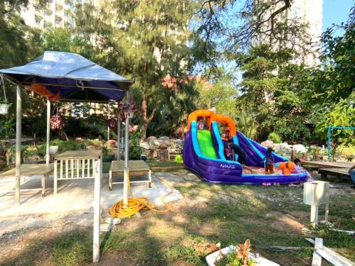 a playground with a slide and an umbrella at Global Star Chalet in Kampong Batang Tiga