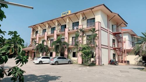 a building with two cars parked in front of it at RuysukJo Resort&Pool in Udon Thani