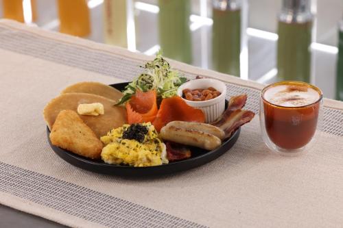 a plate of breakfast food on a table with a drink at Camlux Hotel in Hong Kong