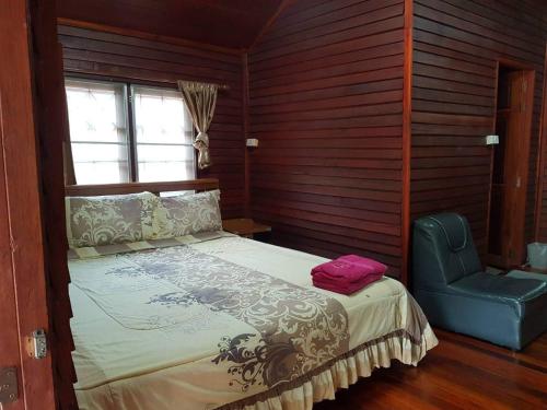 um quarto com uma cama e uma cadeira azul em RuysukJo Resort&Pool em Udon Thani