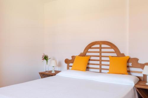 a bedroom with a large white bed with yellow pillows at Gitavillage Club degli Amici in Pescia Romana