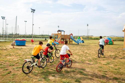 a group of children riding bikes in a park at Gitavillage Club degli Amici in Pescia Romana