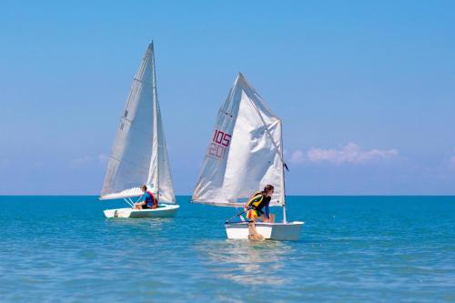 two men on small sailboats in the ocean at Gitavillage Club degli Amici in Pescia Romana