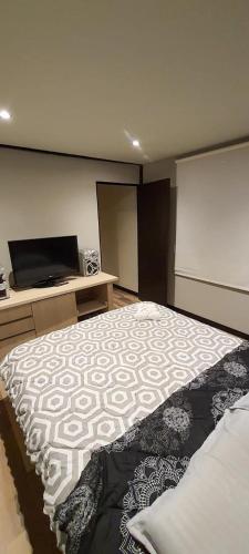 a bedroom with a bed and a flat screen tv at Royal Colving Apartaestudio en Chía in Chía