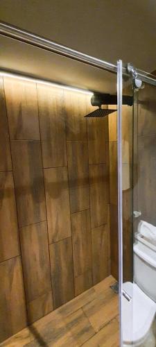 a bathroom with a toilet and a wooden wall at Royal Colving Apartaestudio en Chía in Chía