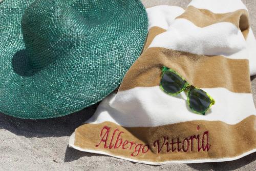 
a hat on a towel on a beach at Hotel Vittoria in Trapani
