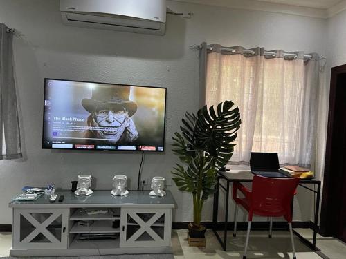 ein Wohnzimmer mit einem Flachbild-TV an der Wand in der Unterkunft Idyllic Condo in Liguanea in Kingston