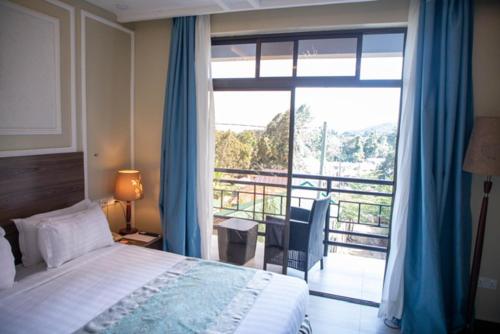 a bedroom with a bed and a view of a balcony at Greenside Hotel in Arusha