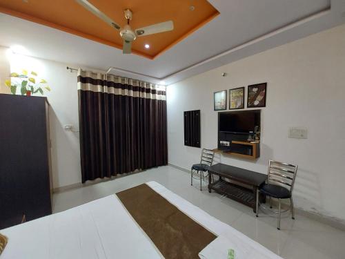 1 dormitorio con cama, mesa y TV en Taj Rama Manage By Taj Sunrise Group, en Agra