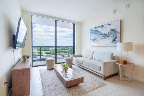 a living room with a white couch and a large window at Stunning Apartment in Downtown Doral in Miami