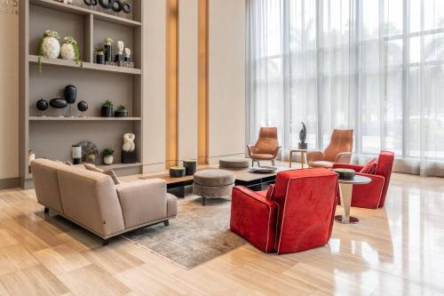 a living room with couches and chairs and a table at Stunning Apartment in Downtown Doral in Miami