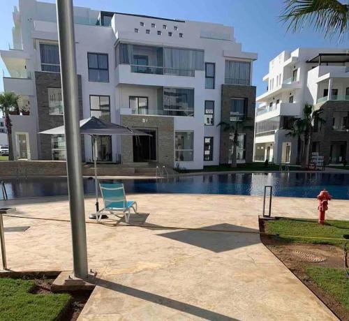 a fire hydrant next to a building with a pool at Luxe résidence Hivernage in Agadir