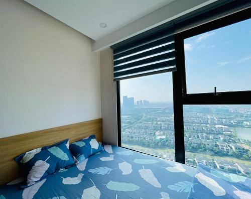 um quarto com uma cama e uma grande janela em BOM HOMES- ECOPARK- SERVICE APARTMENt em Kim Quan
