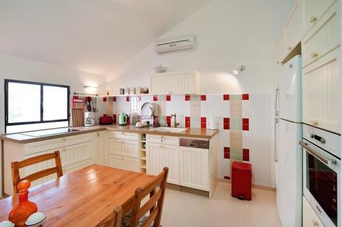 eine Küche mit weißen Schränken und einem Holztisch in der Unterkunft Lovely 2BR Apt w Balcony in Neve Tzedek Area Sea N' Rent in Tel Aviv