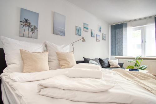 a large bed with white sheets and pillows at Homefy Sleep & Relax Apartment mit frei parken, in Toplage in Essen