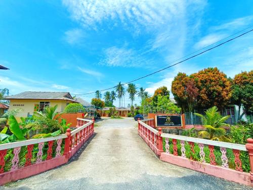 a bridge over a road in front of a house at Chalet Yunie Marang by RVH in Kampong Ru Dua