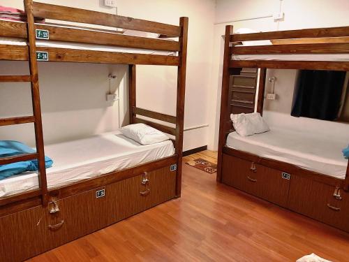two bunk beds in a room with wooden floors at Utopia Hostels Dharamkot Mcleodganj in Dharamshala