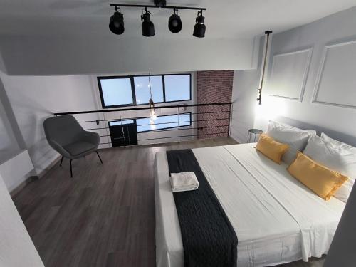 a bedroom with a bed and a chair in it at ZOE LOFT in Kavála