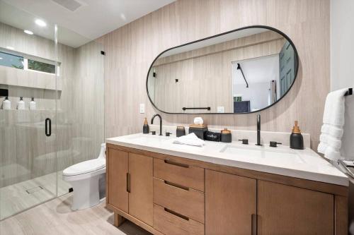 een badkamer met een wastafel, een spiegel en een toilet bij Chic 3BR Oasis in Studio City:Toluca Lake Adjacent in Los Angeles