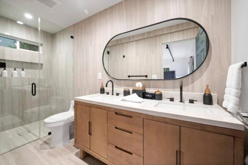 a bathroom with a sink and a mirror and a toilet at Chic 3BR Oasis in Studio City:Toluca Lake Adjacent in Los Angeles