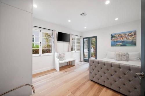 a white living room with a couch and windows at Chic 3BR Oasis in Studio City:Toluca Lake Adjacent in Los Angeles