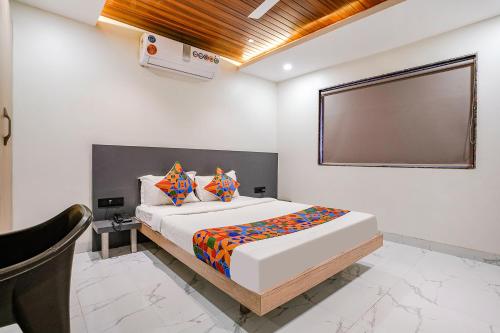 a bedroom with a large bed with avertisementatronatronstrationstrationstrationstrationstration at FabHotel Ansh in Aurangabad