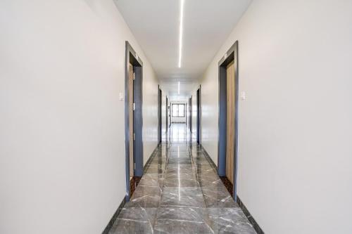 a hallway with white walls and a tile floor at FabHotel Ansh in Aurangabad