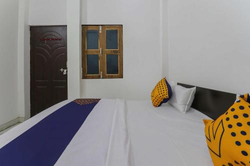 a room with a bed with a window and a door at OYO 78880 Rajdhani Hotel in Kākori