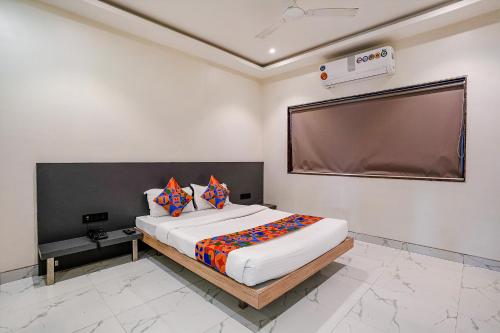 a bedroom with a large bed and a large screen at FabHotel Ansh in Aurangabad