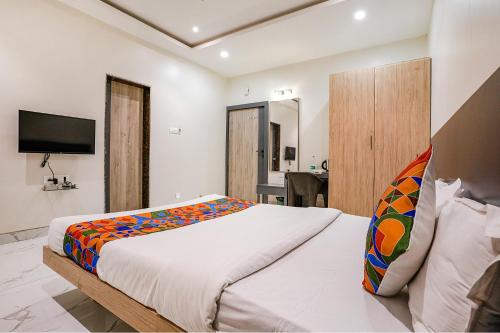 a bedroom with a large bed and a television at FabHotel Ansh in Aurangabad